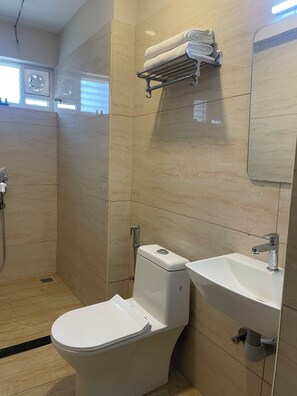 A bathroom with a toilet, sink, and shower.
