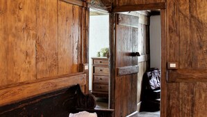 Interior de madeira com um banco e uma porta que dá para outro cômodo.