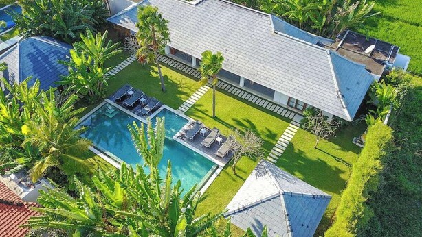Ein Resort mit Schwimmbad, Liegebereichen und üppiger Bepflanzung.