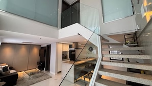 Ein modernes Interieur mit Wendeltreppe aus Glas, einer Küchenzeile und einer Sitzecke.