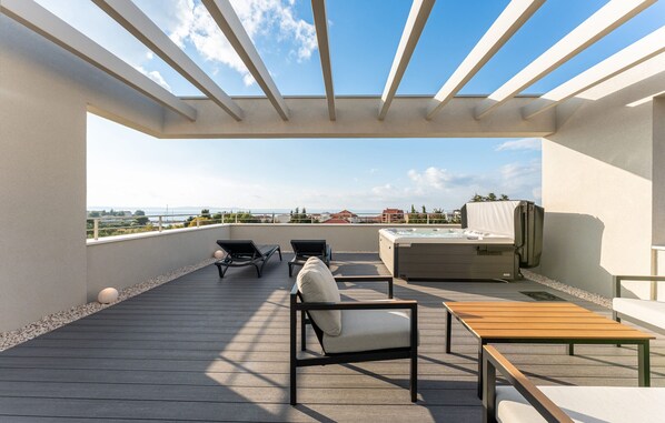 A rooftop terrace with a clear view of the city skyline, a hot tub, and lounge seating. - Villa Suton u Zatonu Zadarvillas (Nin)
