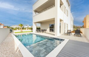 A modern two-story house with a swimming pool, outdoor seating, and a view of the surrounding neighborhood. - Villa Suton u Zatonu Zadarvillas (Nin)
