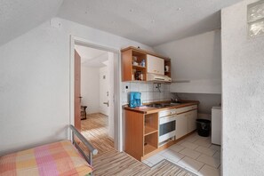 Eine kleine Küche mit Holzausstattung, einem Herd und einer Kaffeemaschine.