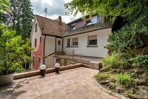 A residential building with a tiled patio, a staircase, and a garden area. - Apartment '4' with Shared Terrace and Wi-Fi (Baden-Baden)