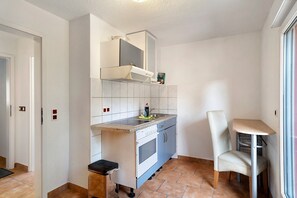 A compact kitchen with a built-in oven, a microwave, and a small sink.