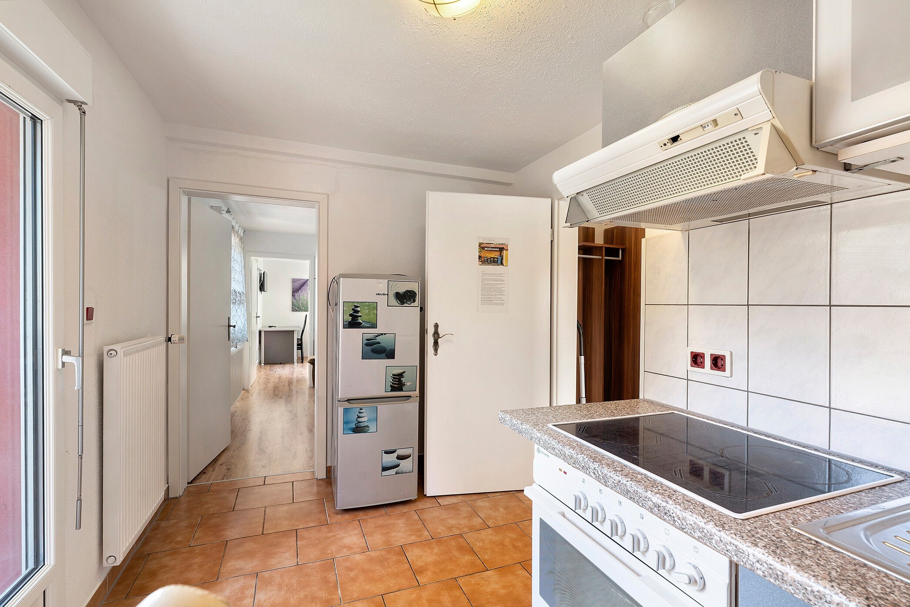 Una cocina con estufa integrada, refrigerador y salpicadero de azulejos.