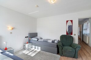 A bedroom with a bed, bedside table, lamp, chair, and a painting on the wall. - Apartment '4' with Shared Terrace and Wi-Fi (Baden-Baden)