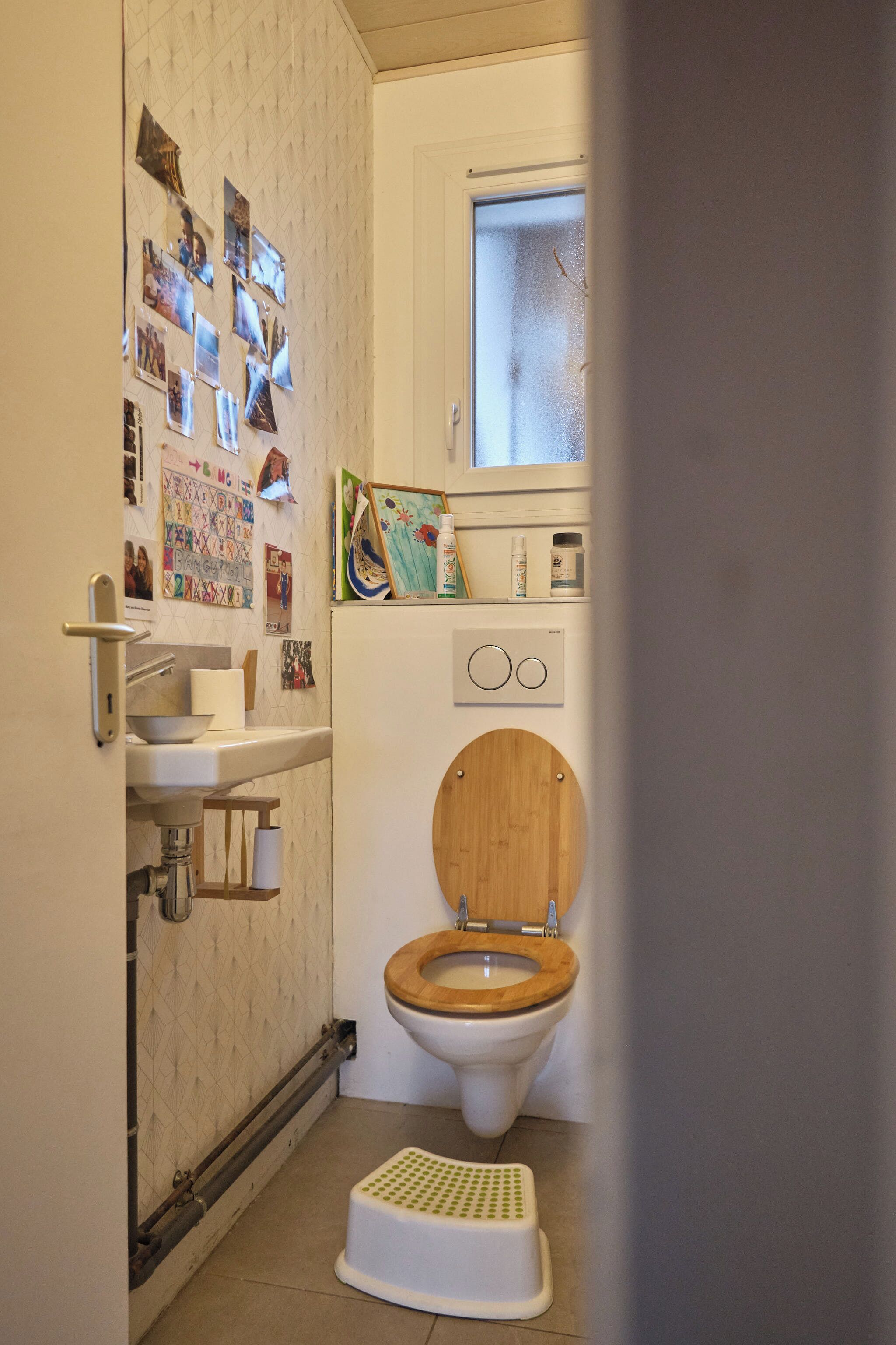Een compacte badkamer met toilet, wastafel en een opstapje.