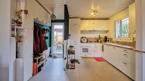 Una cocina moderna con armarios blancos, horno empotrado y una ventana que proporciona luz natural.