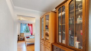 Quarto com um armário de madeira, uma cama e uma janela com cortinas.