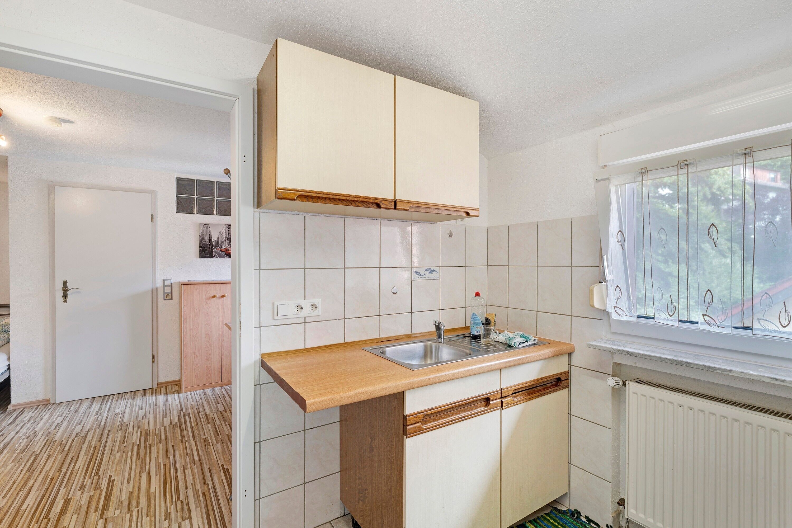 Une cuisine dotée d’un plan de travail en bois, d’un évier encastré et de meubles blancs.