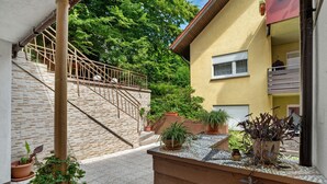 A residential building with a staircase leading to a balcony, potted plants, and a window with a white blind. - Room '3' with Shared Terrace and Wi-Fi (Baden-Baden)