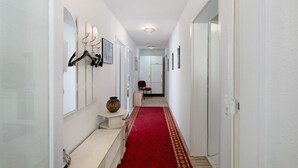 A hallway with white walls, a red carpet, and a bench. - Room 7 with Shared Terrace and Wi-Fi (Baden-Baden)