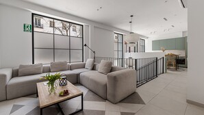 Een moderne woonkamer met een hoekbank, een houten salontafel en een groot raam.