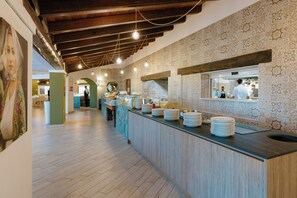 Eine lange Buffettheke mit Marmorplatte, Holzbalken an der Decke und Wandfliesen mit Muster.