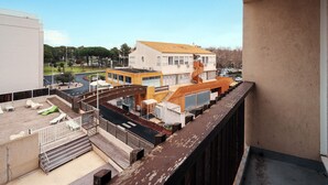 A rooftop terrace with a view of a building with a yellow roof and a white facade. - Charming Apart for 4 Near the Sea (Agde)
