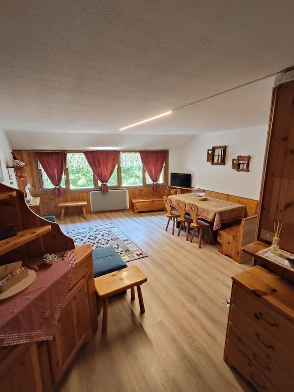 A cozy room with a wooden bench, a table, and a TV.