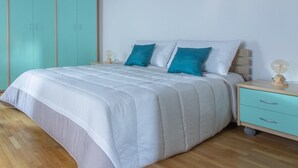 A bedroom with a bed, two nightstands, a wardrobe, and a small desk.