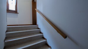 A staircase with wooden handrails and a window at the top. - GuestHost - Cozy and practical 62 square meters apartment, perfect for four people, located on the second floor of a renovated period building (NO elevator).The property is located in the center of Negrar di Valpolicella, a hilltop town in the province o (Negrar di Valpolicella)