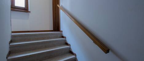 Un escalier avec des rampes en bois et une fenêtre en haut.