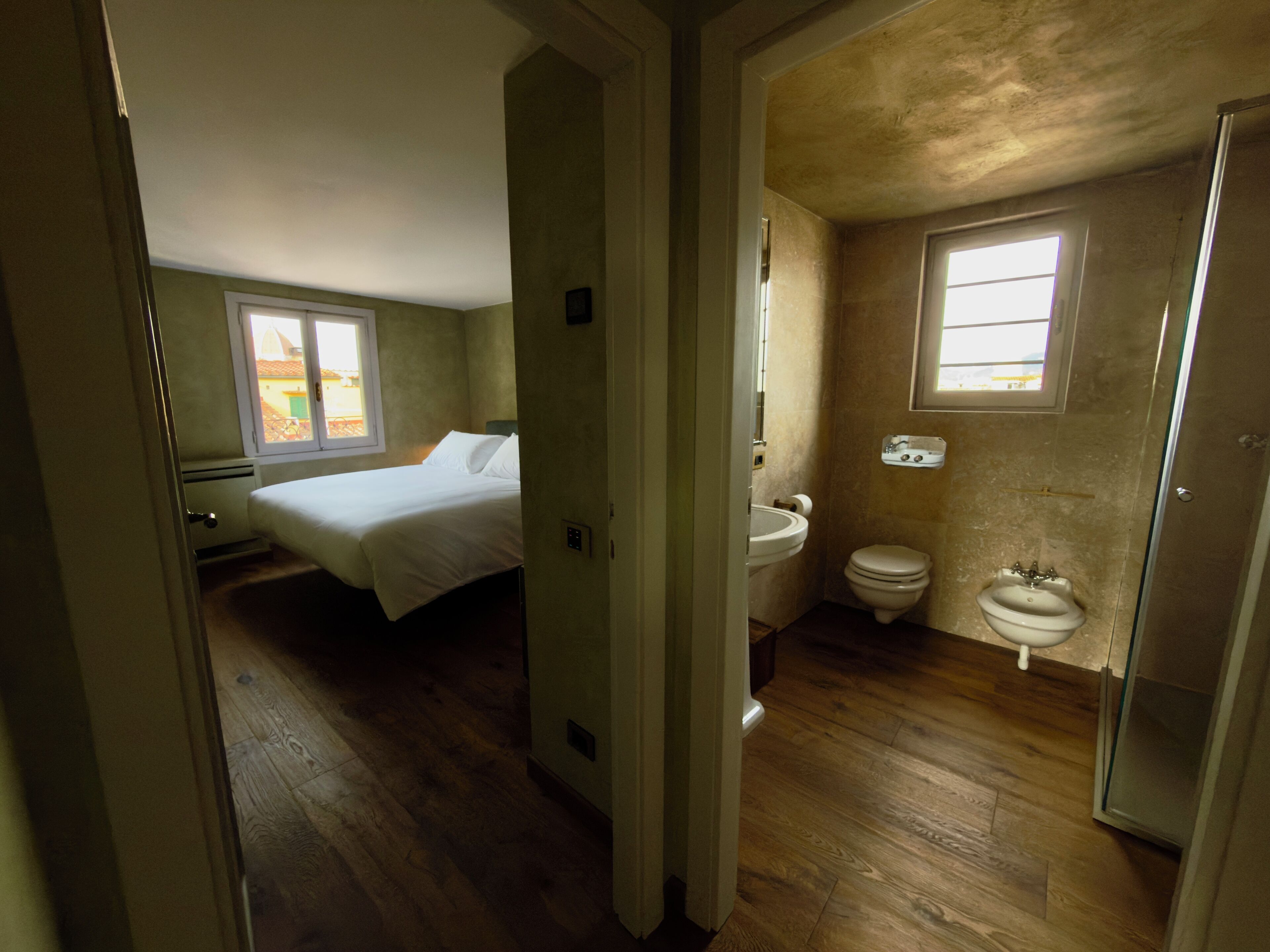 Ein Schlafzimmer mit Bett und einem Badezimmer mit Toilette und Waschbecken.