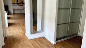 A hallway with wooden flooring leading to a room with a sliding glass door. - AN EXCEPTIONAL PARISIAN EXPERIENCE CLOSE TO ODEAN & LUXEMBOURG – SAINT GERMAIN (Paris)