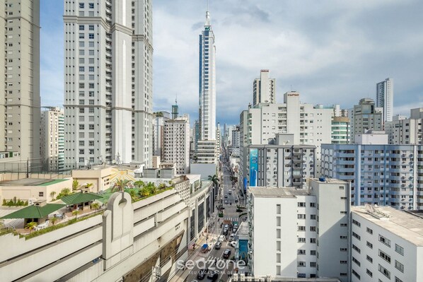 Un paysage urbain avec de hauts immeubles, une tour imposante et une rue animée.