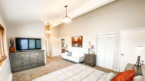 A bedroom with a bed, dresser, TV, and closet. - 2622 N Nevada (Colorado Springs)