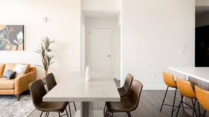 A modern dining area with a rectangular table, brown chairs, a pendant light, and a white door in the background. - 2880 U505 Skytop Perspective at Espadin (Denver)