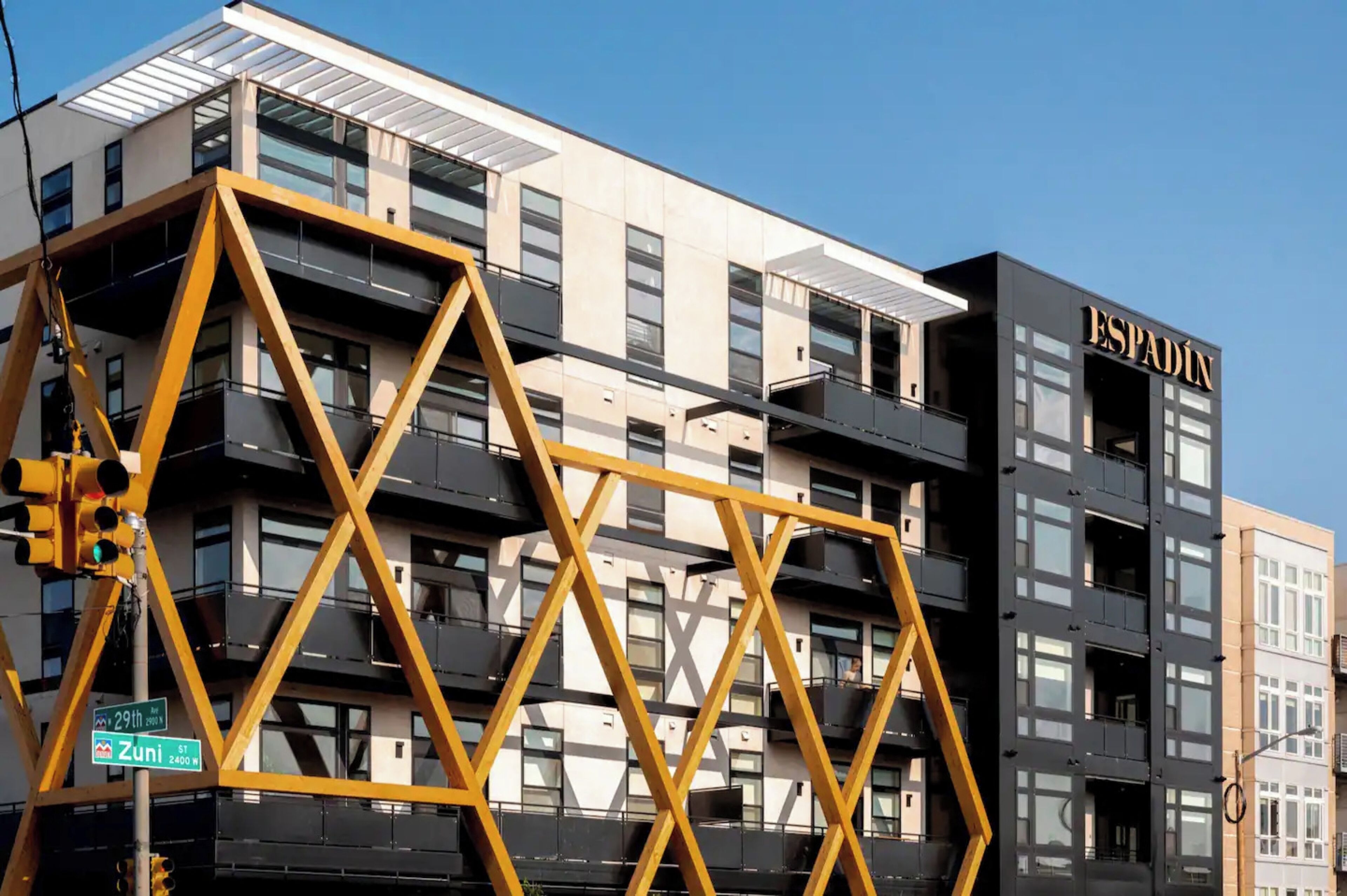 A multi-story building with balconies and a sign reading "ESPADIN".
