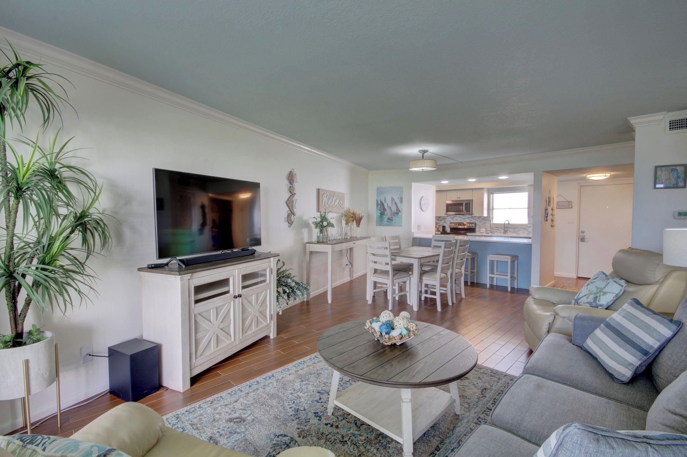 A living room with a TV, sofa, and dining area.