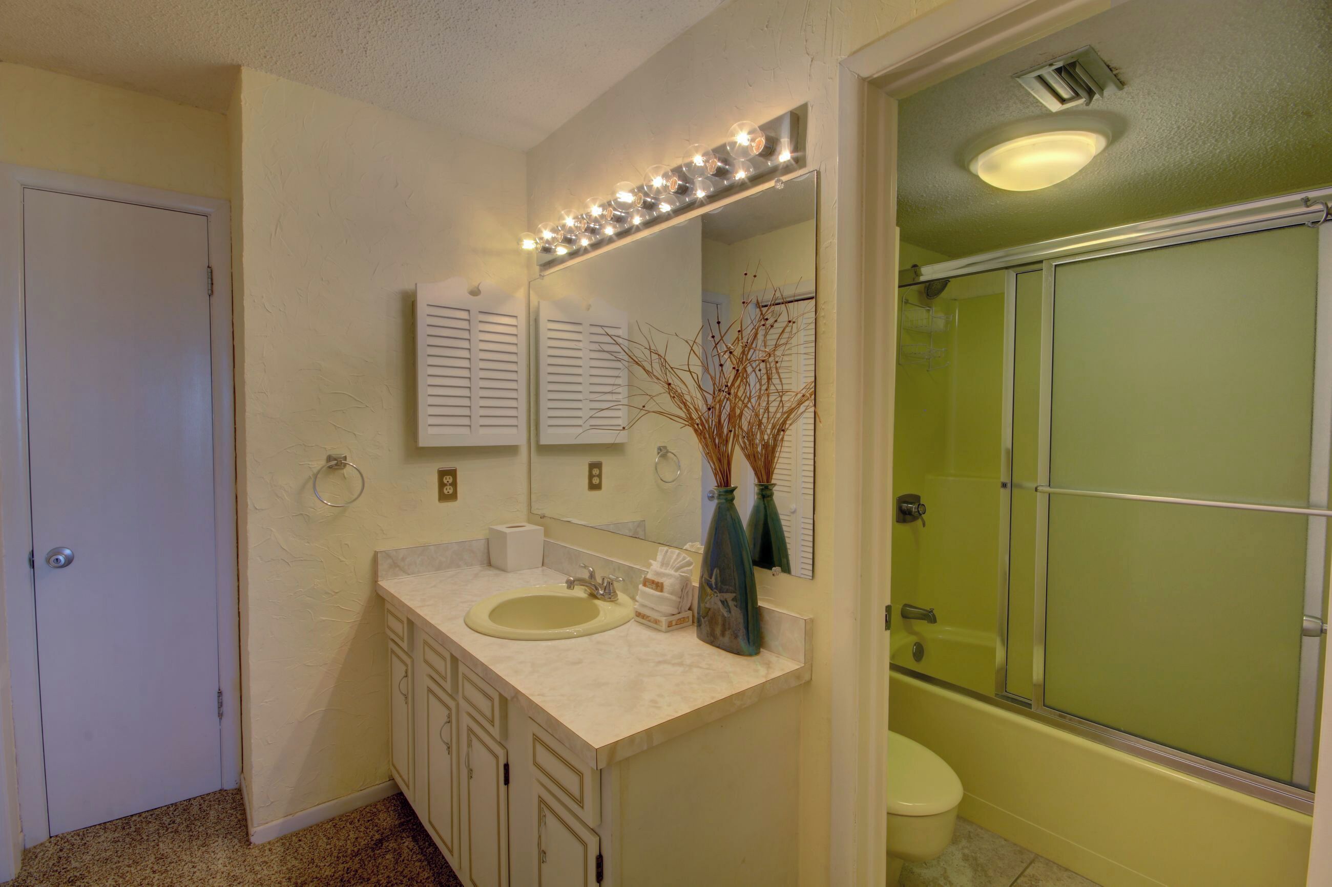 Un baño con lavamanos, espejo y ducha.