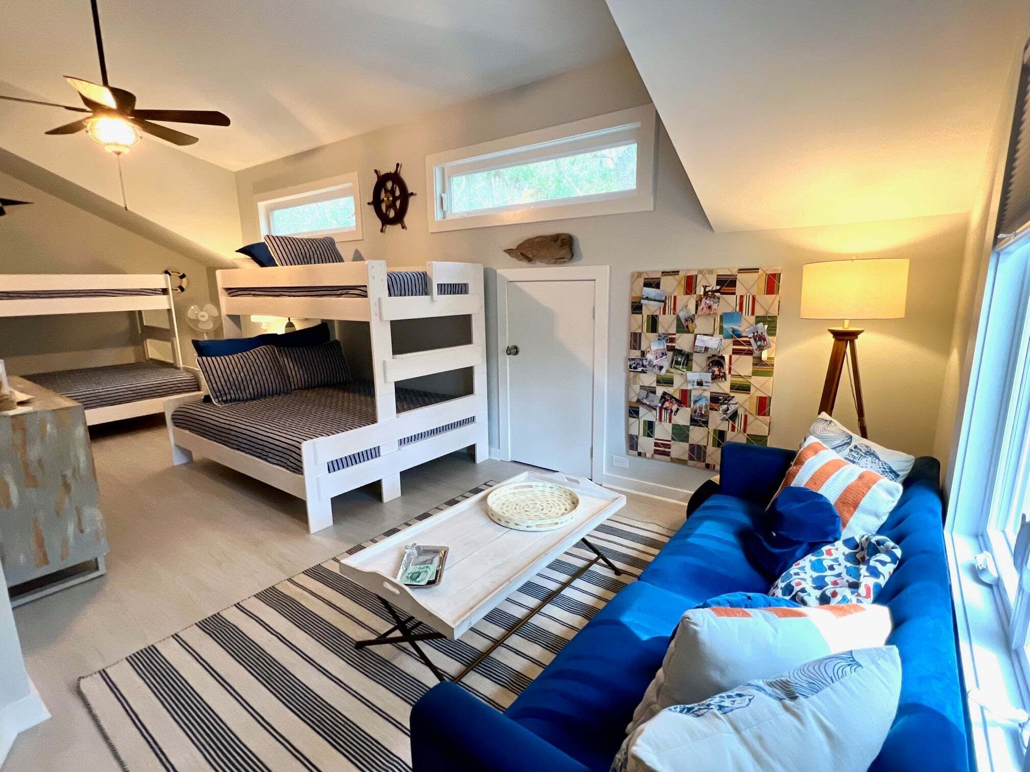 A compact living space with bunk beds, a sofa, a coffee table, and a wall with photos.