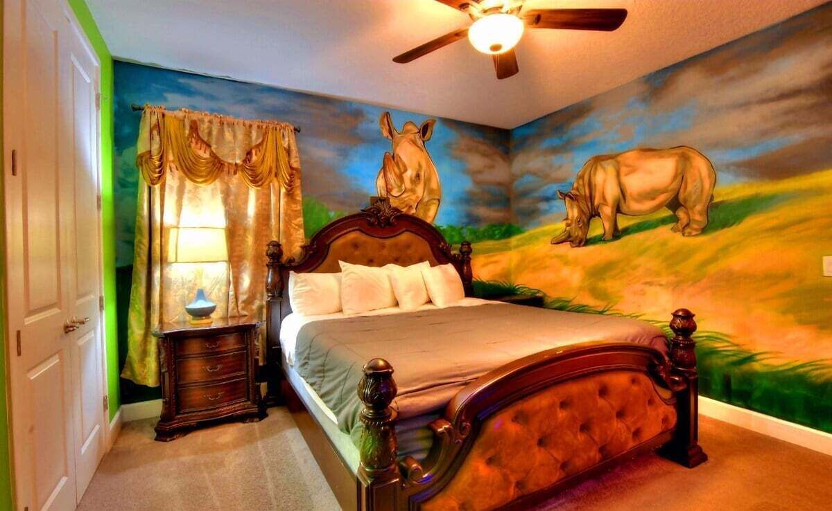 Ein Schlafzimmer mit einem Bett, einem Nachttisch, einer Lampe und einem Deckenventilator.