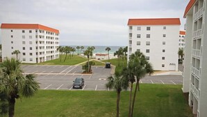 A hotel with a parking lot, palm trees, and a view of the ocean. - 243 El Matador (Fort Walton Beach)
