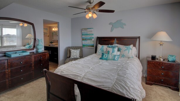 A bedroom with a bed, dresser, nightstand, and ceiling fan. - 243 El Matador (Fort Walton Beach)