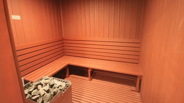 A sauna with wooden benches and a stone heating element. - 235 El Matador (Fort Walton Beach)