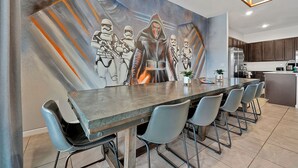 A modern kitchen with dark wooden cabinets, a stainless steel refrigerator, and a built-in oven. - 2496 Shanti Drive,kissimmee,12bed (Kissimmee)