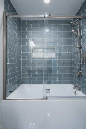 A modern shower enclosure with a glass door, a handheld showerhead, and a wall-mounted faucet. - 2617 Caladium Drive NE, Atlanta (Atlanta)