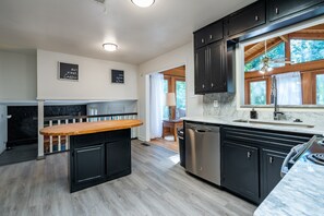 A modern kitchen with dark cabinets, a marble countertop, and a central island. - 2431 Weatherford Court, Marietta (Marietta)