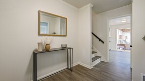 A hallway with a console table, a mirror, and a staircase leading to another room. - 2431 Weatherford Court, Marietta (Marietta)