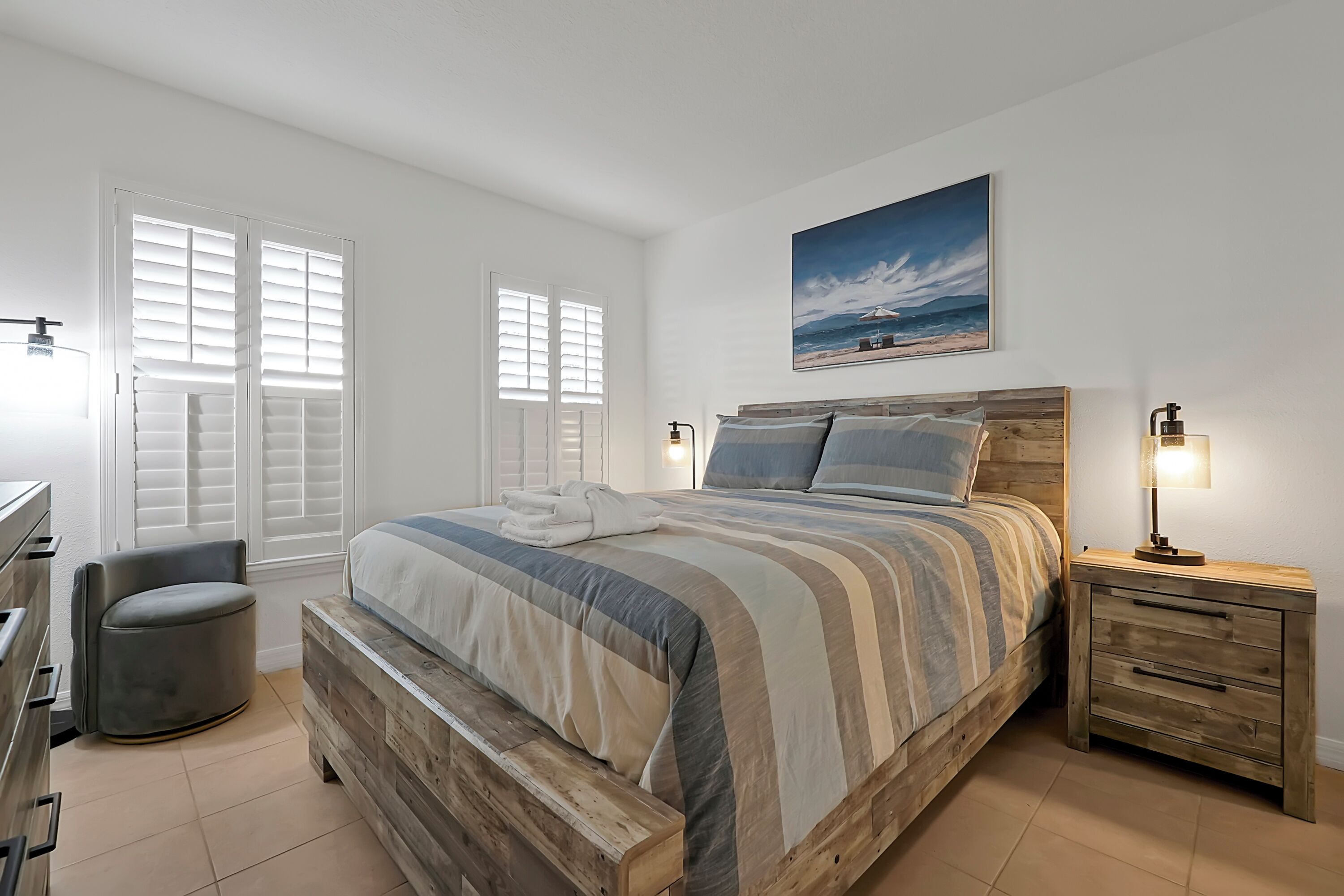 Une chambre à coucher avec un lit en bois, une table de chevet avec une lampe, une chaise et un bureau.