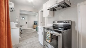 Eine moderne Küche mit Edelstahlgeräten, weißen Schränken und Holzboden.
