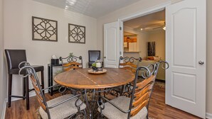 A dining area with a round wooden table, four chairs, and two wall-mounted decorative panels. - 27 West Ridge Drive SE, Cartersville (Cartersville)