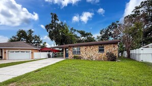A single-story house with a stone facade, a garage, and a well-maintained lawn. - 2737 Bel Aire Circle (Tampa)