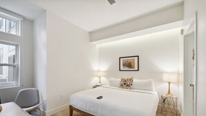 A modern hotel room with a large bed, bedside lamps, a desk, and a chair. - 2880: Natural Influence Sanctuary at Espadin (Denver)