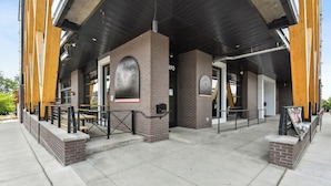 A modern building with a brick facade, large windows, and a covered outdoor seating area. - 2880: Rhythm of the Night Loft at Espadin (Denver)