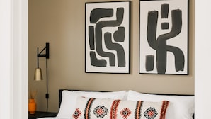 A bedroom with a bed, two abstract paintings, a lamp, and a decorative pillow. - 2880: Rhythm of the Night Loft at Espadin (Denver)