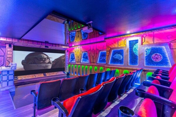 Una sala cinematografica con file di posti a sedere e uno schermo che mostra un film.