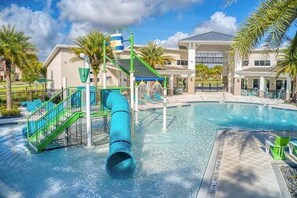 En swimmingpool med vandrutsjebane og et overdækket område med stole.